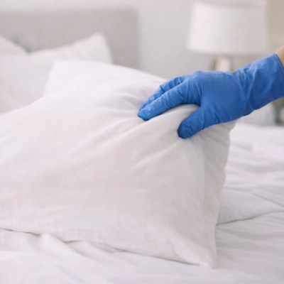 Hand adjusting a white pillow